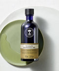 On a lovely green plate with a white linen, Neal's Yard Remedies Aromatic Massage Oil is shown. 