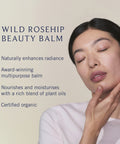 Woman applying Wild Rosehip Beauty Balm with product description text on a beige background